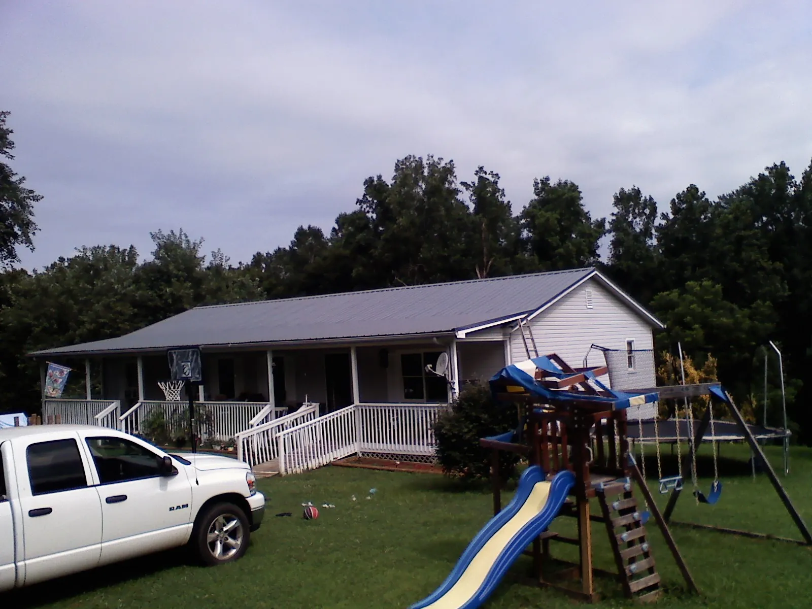 Dark metal roof on a country home with a full length front porch in Huntington